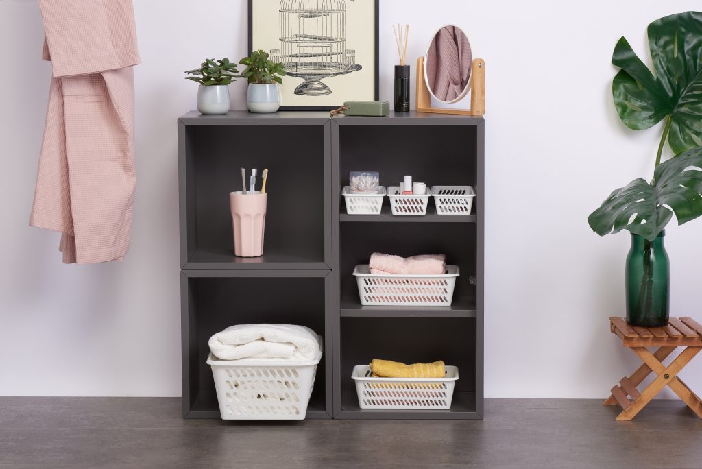 Classic Mini baskets in many various sizes are the perfect bathroom storage solution. Containers in 3 different sizes are placed inside a cupboard holding towels and other bathroom accessories.