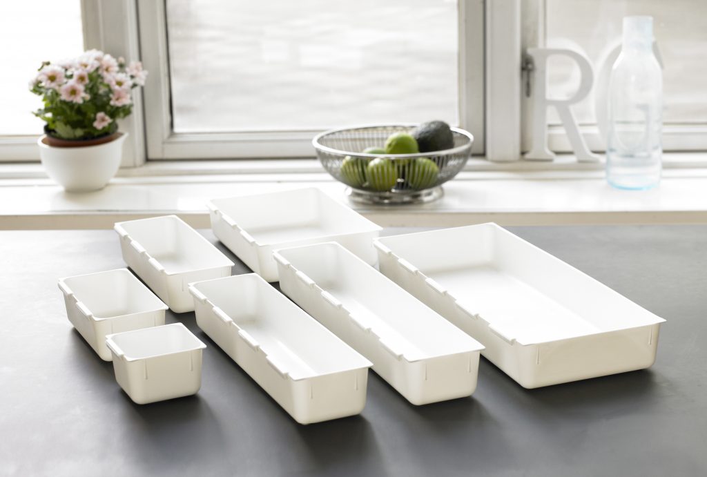 Modular drawer organizer in a broad range of sizes, they are standing on the tabletop.