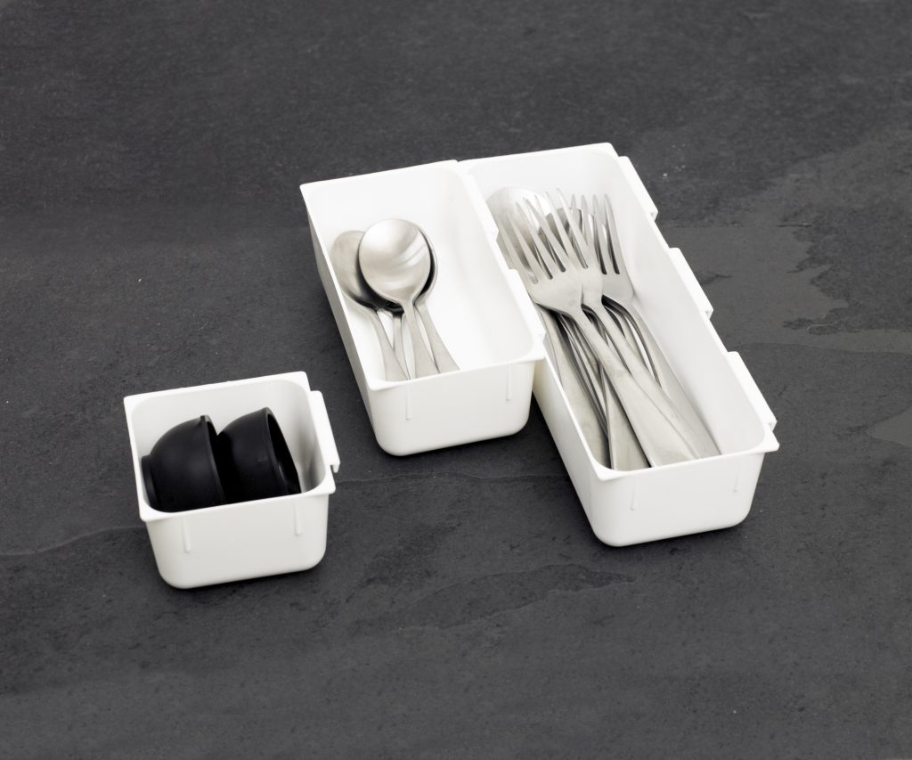 Modular drawer organizers with a minimalistic design, they are standing on the tabletop.