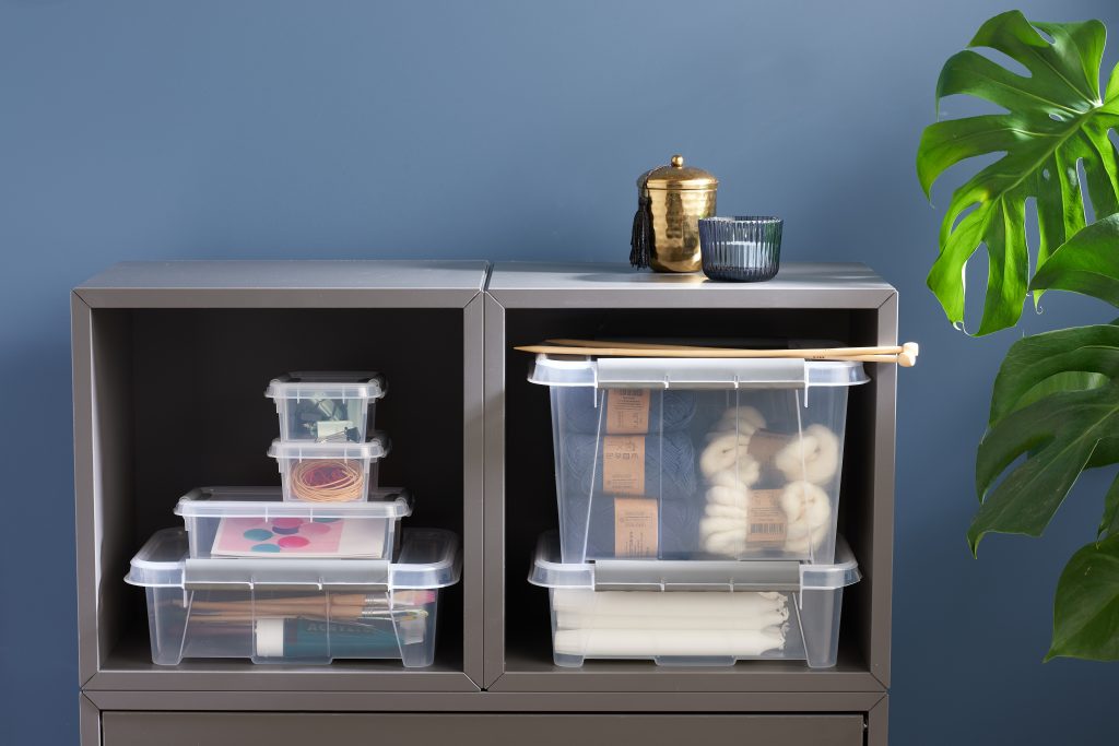 Stackable translucent Probox clip-closed storage boxes in four different sizes, with QR codes to organize storage. Boxes are placed inside a bookcase and used to store crafting items.